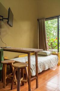 a room with a desk and a bed with a window at Rio Celeste Dreams in Bijagua