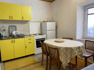 a kitchen with yellow cabinets and a table with chairs at Villa Morena in Trnovo