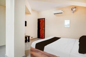 Un dormitorio con una cama y una puerta roja. en Super Hotel O Abbigere Bangalore North Formerly MLV Grand, en Jālahalli 23 fotos más