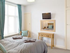 a bedroom with a bed with a mirror and a television at Anchor's Away in Filey