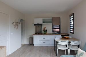 a kitchen with white cabinets and a wooden table at Aumihi Bungalow in HUH