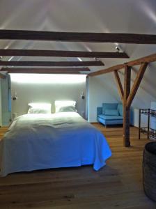 a bedroom with a white bed and a blue couch at Cottage am Waldrand gelegen in Feldkirchen in Kärnten