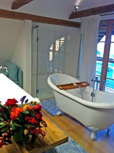 a bathroom with a bath tub and a large window at Cottage am Waldrand gelegen in Feldkirchen in Kärnten