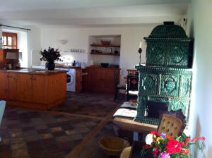 a kitchen with a large green fireplace in a room at Cottage am Waldrand gelegen in Feldkirchen in Kärnten