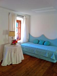 Schlafzimmer mit einem blauen Bett und einem Tisch in der Unterkunft Cottage am Waldrand gelegen in Feldkirchen in Kärnten