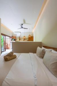 a large white bed in a bedroom with a ceiling at Casa Komang, lovely studio in central Bingin in Uluwatu