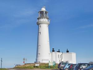 un faro con macchine parcheggiate di fronte di Elm Tree Cottage a Foxholes 1 altra foto