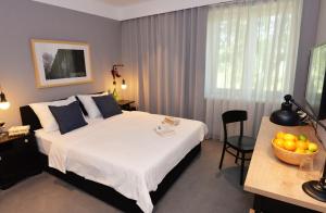 a bedroom with a bed and a table with a bowl of fruit at The Loop Hotel in Zagreb