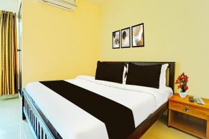 a bedroom with a large bed in a room at Super Collection O Kureepuzha Kollam in Kollam