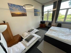 a bedroom with two beds in a room with windows at EcoLodge Loft Comfortable holiday residence in Oesterdeichstrich