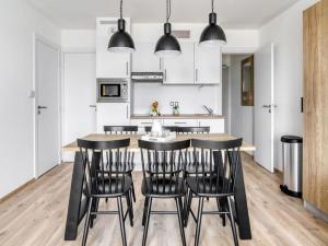 Una cocina con una mesa de madera y sillas negras. en Apartments on the Côte d'Opale, en Boulogne-sur-Mer