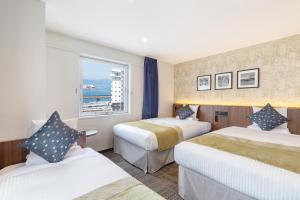 a hotel room with two beds and a window at HOTEL MYSTAYS Hakodate Station in Hakodate +129 photos