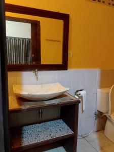 Brown Sugar Homestay في غيلي تراوانغان: حمام مع حوض ومرآة