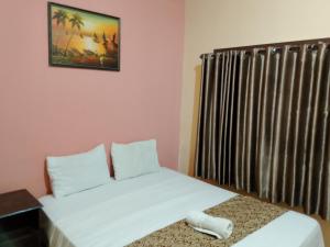 Brown Sugar Homestay في غيلي تراوانغان: غرفة نوم بسرير أبيض ونافذة +19 صورة