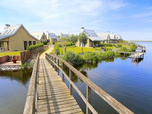 a row of houses next to a body of water at Villa Oesterdam Sleeps 8 persons in Tholen