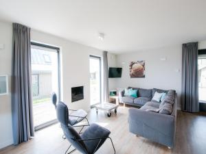 a living room with a couch and two chairs at Villa Oesterdam Sleeps 8 persons in Tholen