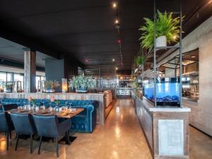 a restaurant with tables and chairs and a large aquarium at Villa Oesterdam Sleeps 8 persons in Tholen