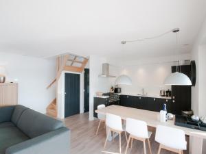 a kitchen and living room with a table and chairs at Villa Oesterdam Sleeps 8 persons in Tholen +32 photos