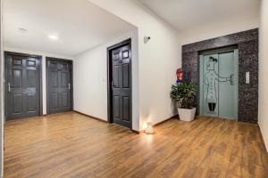 an empty room with two doors and wooden floors at Hotel O Evergreen in Faridabad