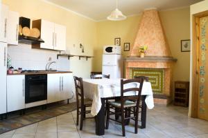 een keuken met een tafel met stoelen en een open haard bij Casa Vacanza da Luisa in San Giovanni Suèrgiu