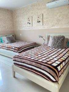 two beds sitting next to each other in a bedroom at Apartamento salida al Mar Santa Marta in Santa Marta