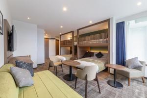 a hotel room with two beds and a couch at HOTEL MYSTAYS Hakodate Station in Hakodate