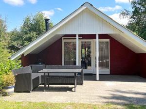ein Picknicktisch vor einem roten Haus in der Unterkunft 6 person holiday home in Toftlund in Toftlund
