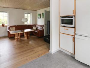 a kitchen and living room with a couch and a table at 6 person holiday home in Hadsund-By Traum in Hadsund
