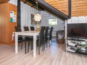a dining room with a white table and black chairs at Secluded Oasis by Kvie Lake-By Traum in Ansager