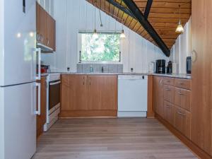 a kitchen with wooden cabinets and a white refrigerator at Secluded Oasis by Kvie Lake-By Traum in Ansager