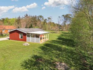 a red and white house in the middle of a yard at 6 person holiday home in Hals-By Traum in Hals