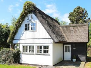 ein weißes Cottage mit einem Strohdach in der Unterkunft Tranquil Waterfront Cottage-By Traum in Hadsund