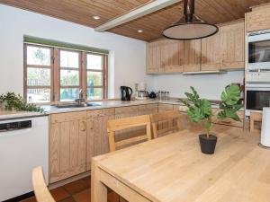 una cocina con armarios de madera y una mesa con una maceta. en 5 person holiday home in Børkop-By Traum, en Børkop