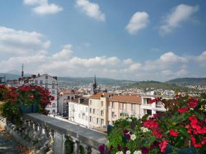 een balkon met bloemen en uitzicht op de stad bij Residhome Clermont Ferrand Gergovia in Clermont-Ferrand