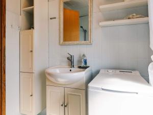 a bathroom with a sink and a washing machine at 6 person holiday home in Læsø in Læsø +37 photos