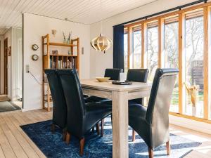 comedor con mesa de madera y sillas negras en 6 person holiday home in Læsø, en Læsø