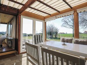 Un comedor con mesa y sillas y ventanas. en 8 person holiday home in Harpelunde, en Harpelunde