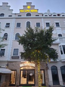 a large white building with a tree in front of it at Mai Linh Hotel in Ha Long