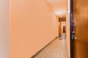 an empty hallway with a door and a tile floor at Hotel O Dakshin Dwar Formerly Radha Krishna Niwas in Puri