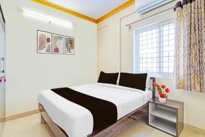 a white bedroom with a bed and a window at Collection O Niladri Road in Kammasandra +37 photos