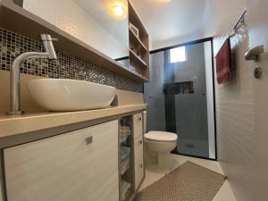 a bathroom with a sink and a toilet at Apartamento próx praia in Balneário Camboriú