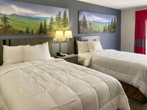 two beds in a hotel room with two beds sidx sidx sidx at Clarion Pointe - Greensboro Coliseum Area in Greensboro +19 photos