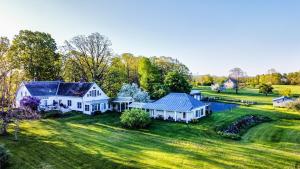 una vista aérea de una casa blanca en un campo verde en Whitford House historic retreat, en Addison