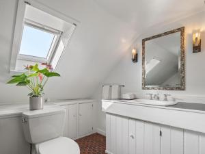 Un baño blanco con inodoro y espejo. en Whitford House historic retreat, en Addison 56 fotos más
