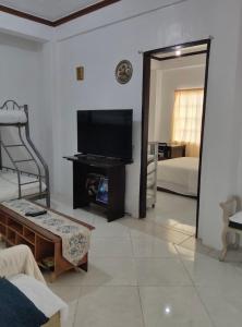 ein Wohnzimmer mit Flachbildfernseher und Couch in der Unterkunft TS Transient House in Baguio City