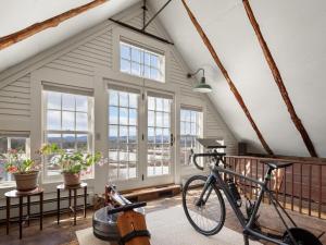 una bicicleta estacionada en una habitación con ventanas en Whitford House historic retreat, en Addison