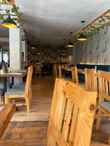 una sala da pranzo con sedie e tavoli in legno e tablesearcher di Velvet Sunrise Hotel a Machu Picchu