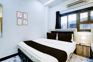 a bedroom with a bed and a window at Hotel O Khar East Near Railway Station in Mumbai