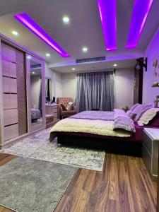 a bedroom with a large bed with purple lighting at Samar Adel in Cairo