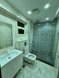 a bathroom with a sink and a toilet and a shower at Samar Adel in Cairo